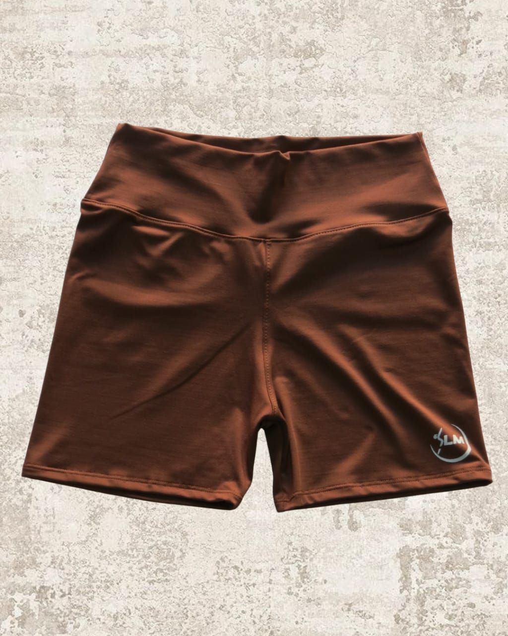 Shorts de ciclista de talle alto de color marrón sobre fondo moteado.