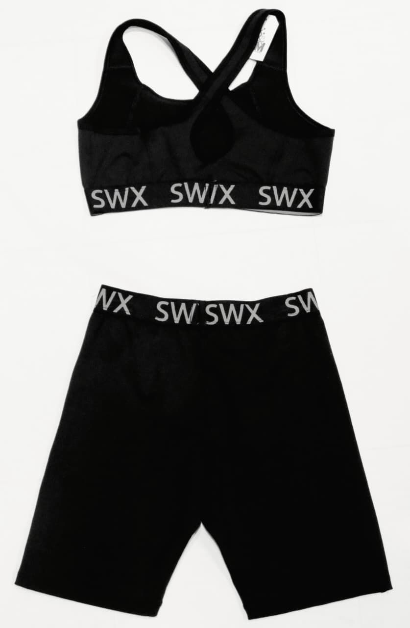 Conjunto de top deportivo negro y pantalones cortos de ciclista con logotipo SWIX en color blanco.