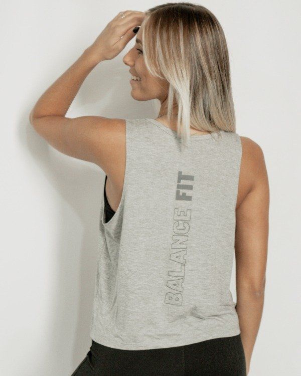 Mujer con una camiseta gris sin mangas con la frase 