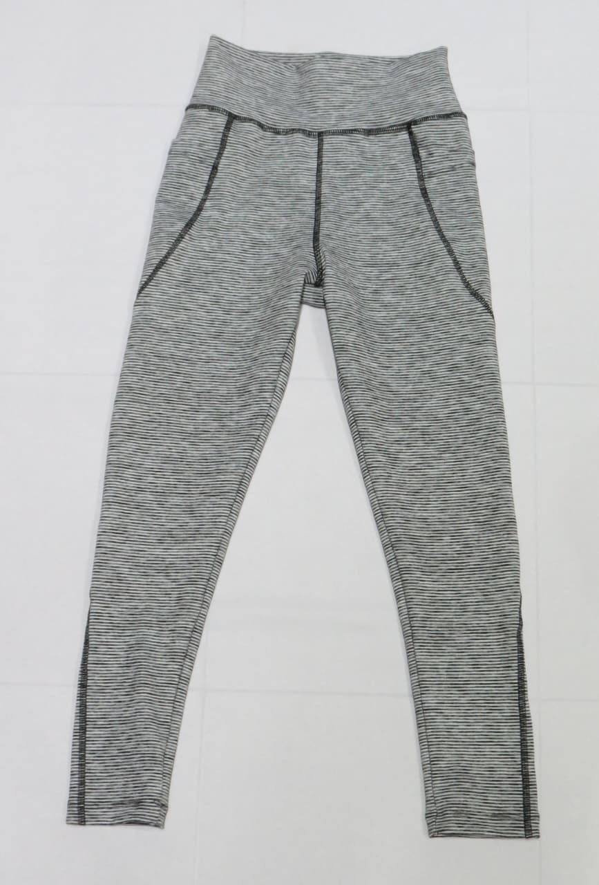 Leggings deportivos de rayas grises y blancas con bolsillos laterales y ribete negro.