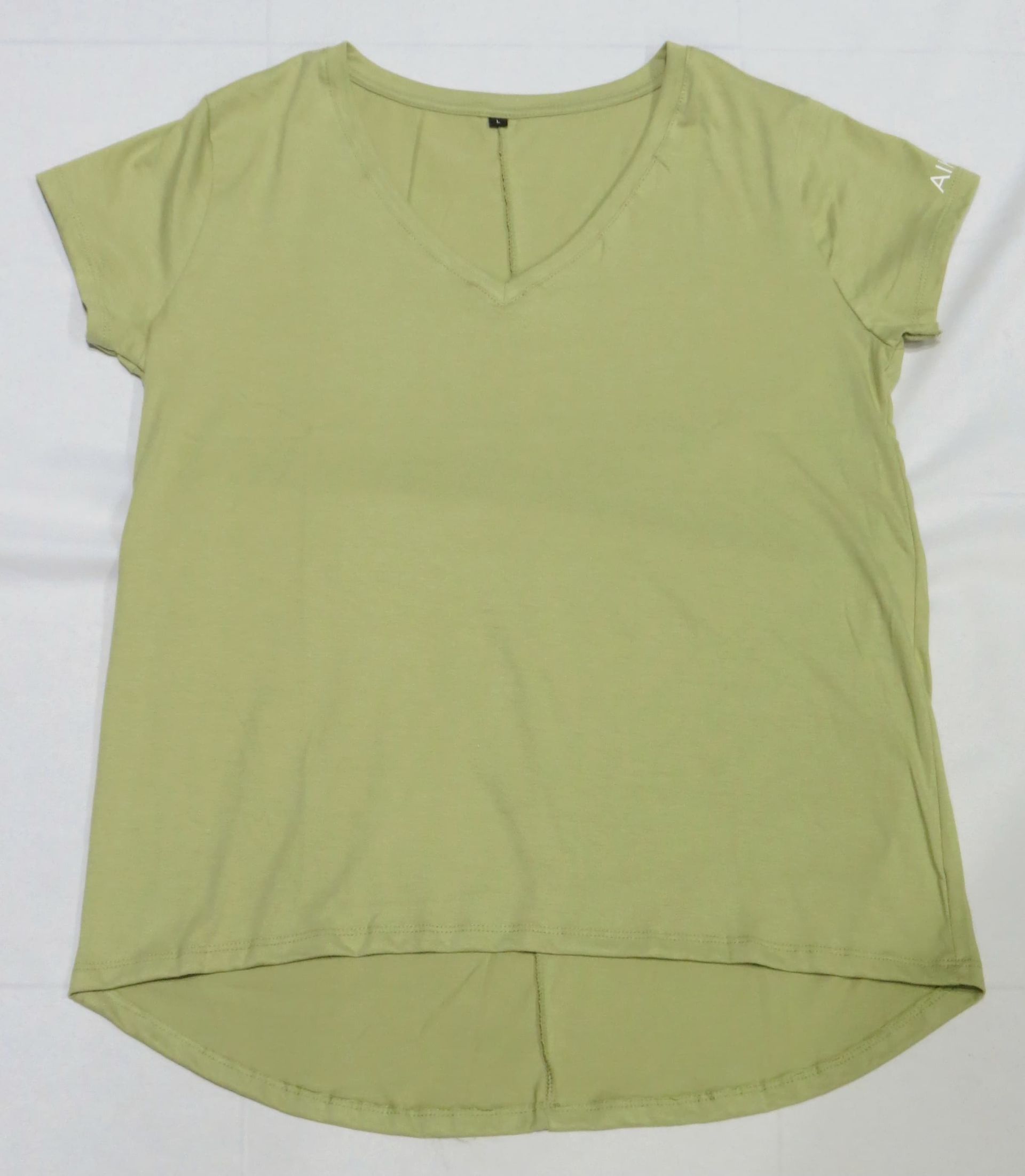 Camiseta verde claro con escote en V, mangas cortas y bajo redondeado, de corte plano.