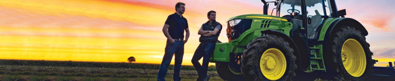 Two John Deere tractors in a field