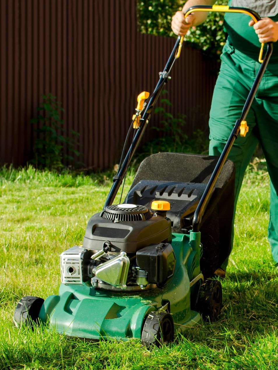 a man is cutting the grass with a lawn mower .