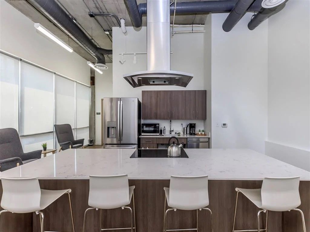 Modern kitchen with island seating, stainless steel appliances, and dark wood cabinetry.
