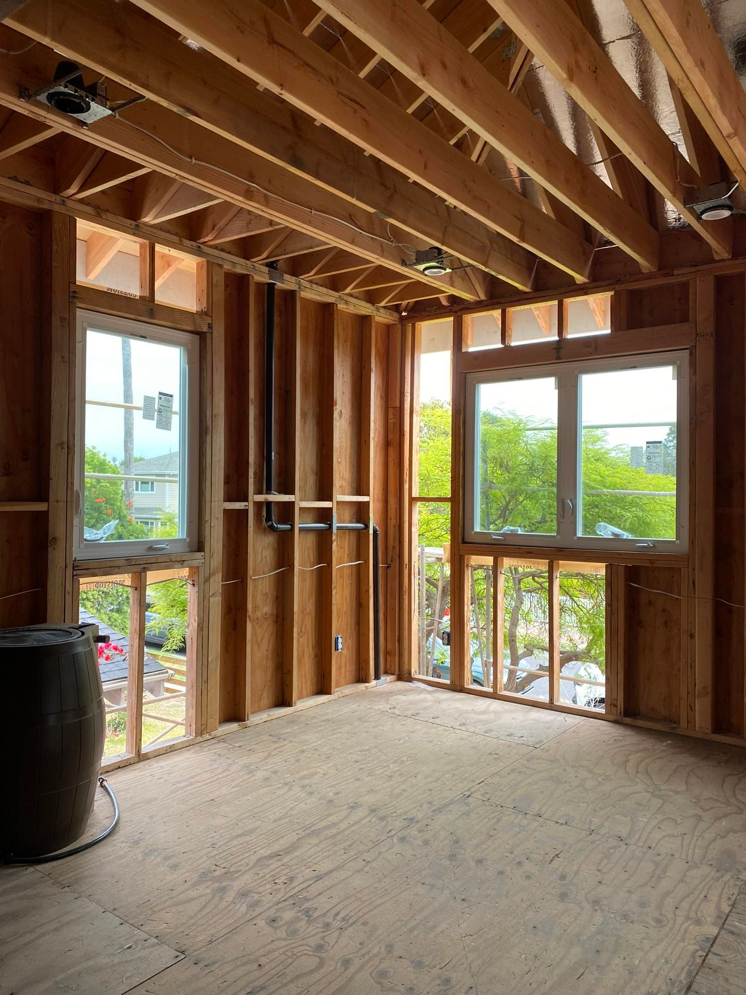 A room in a house under construction with lots of windows