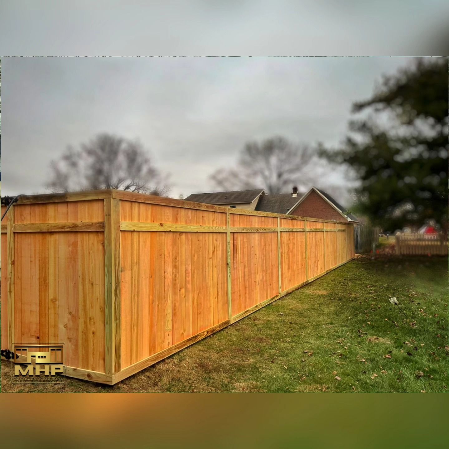 A long wooden fence is sitting in the middle of a grassy field.