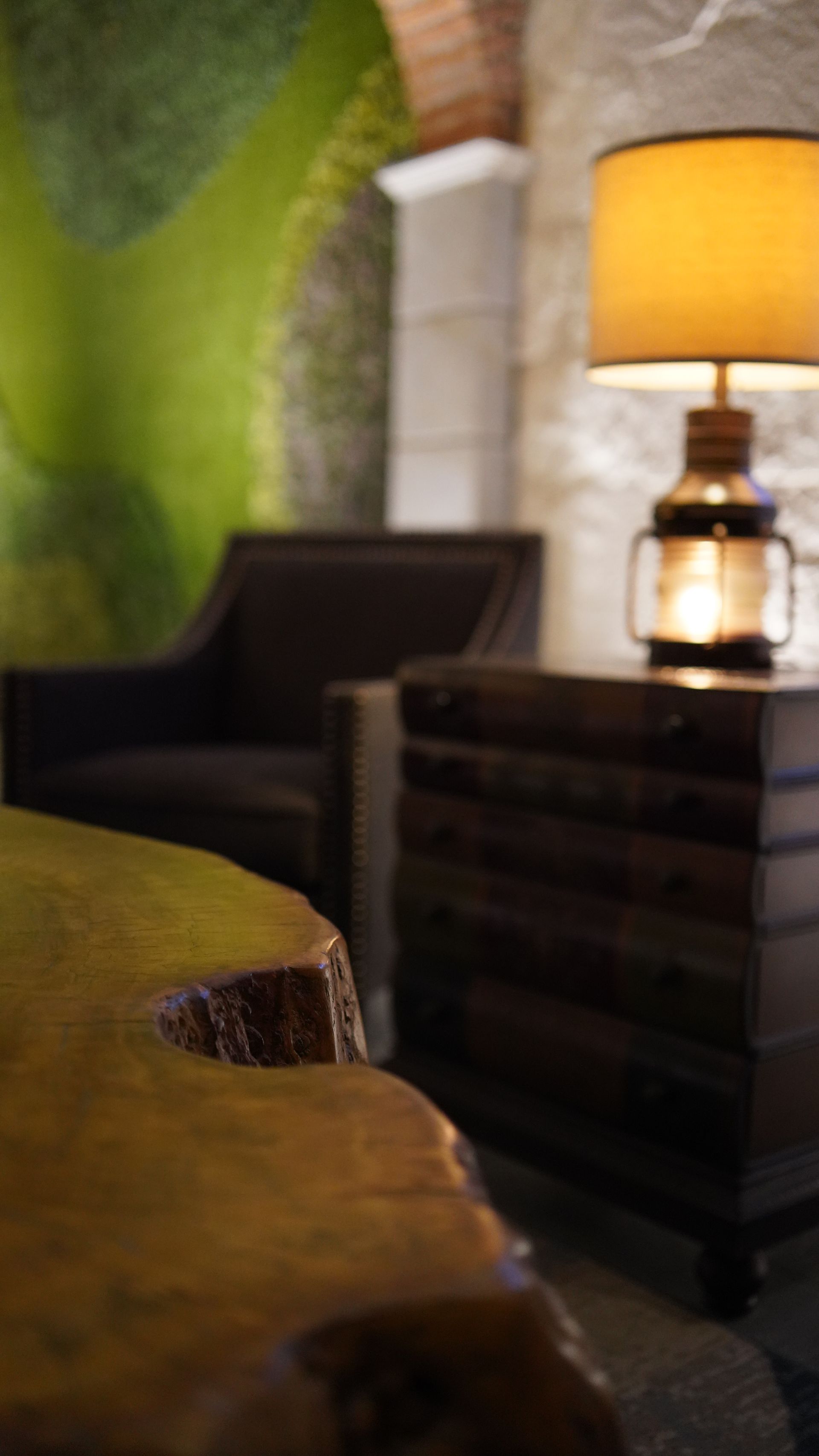 A lamp is sitting on a table next to a chair.