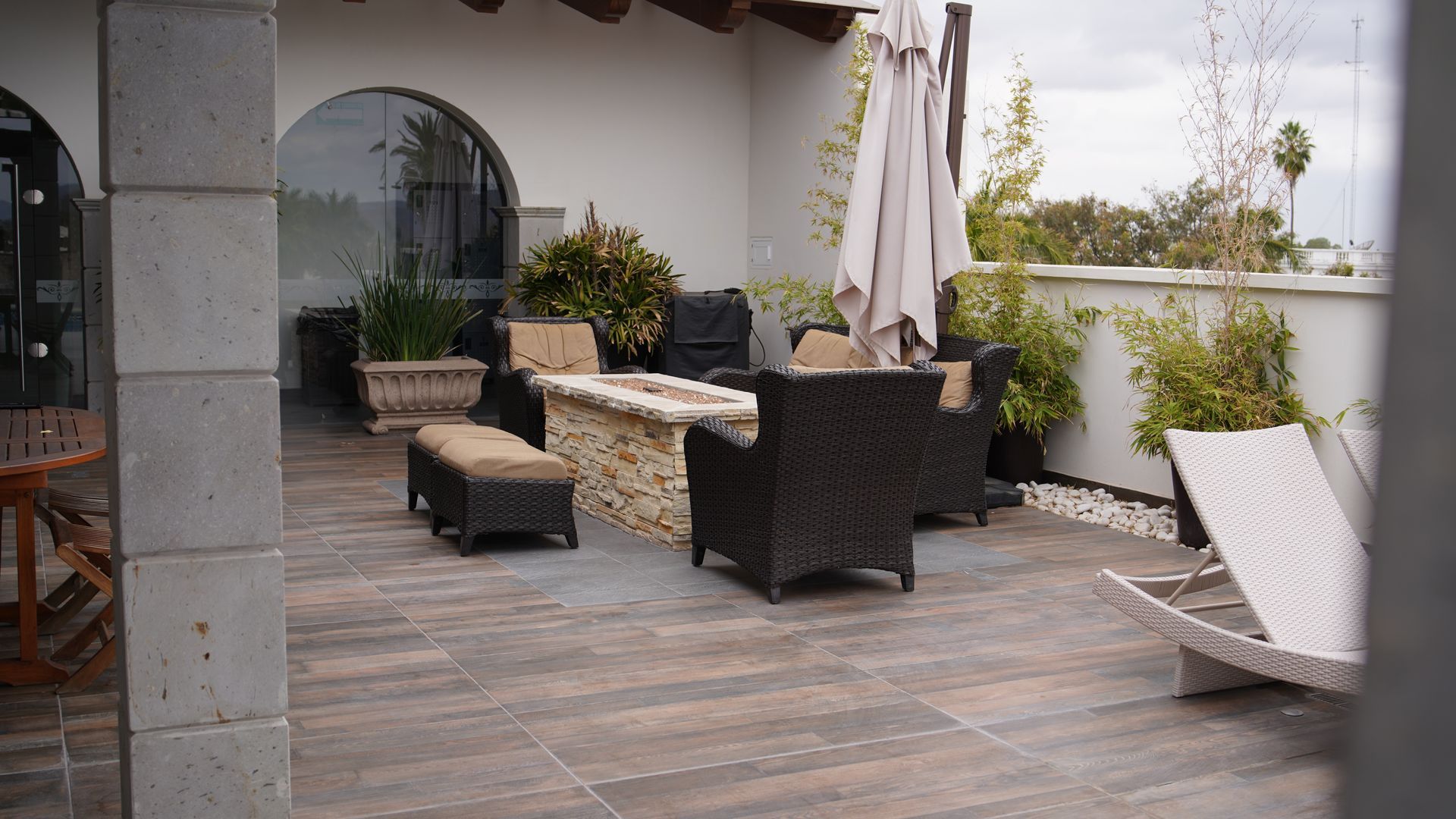 A patio with wicker furniture and a fire pit