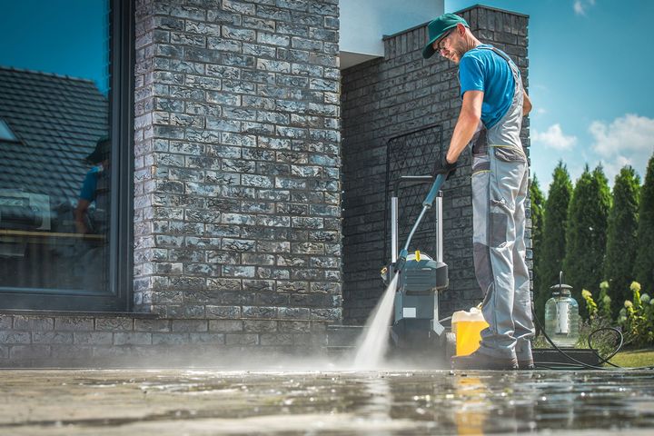 Man Using High Pressure Washer to a Clean Driveway