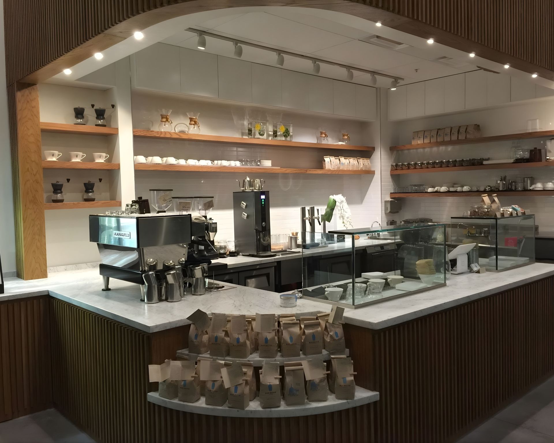 The inside of a restaurant with a counter and shelves.