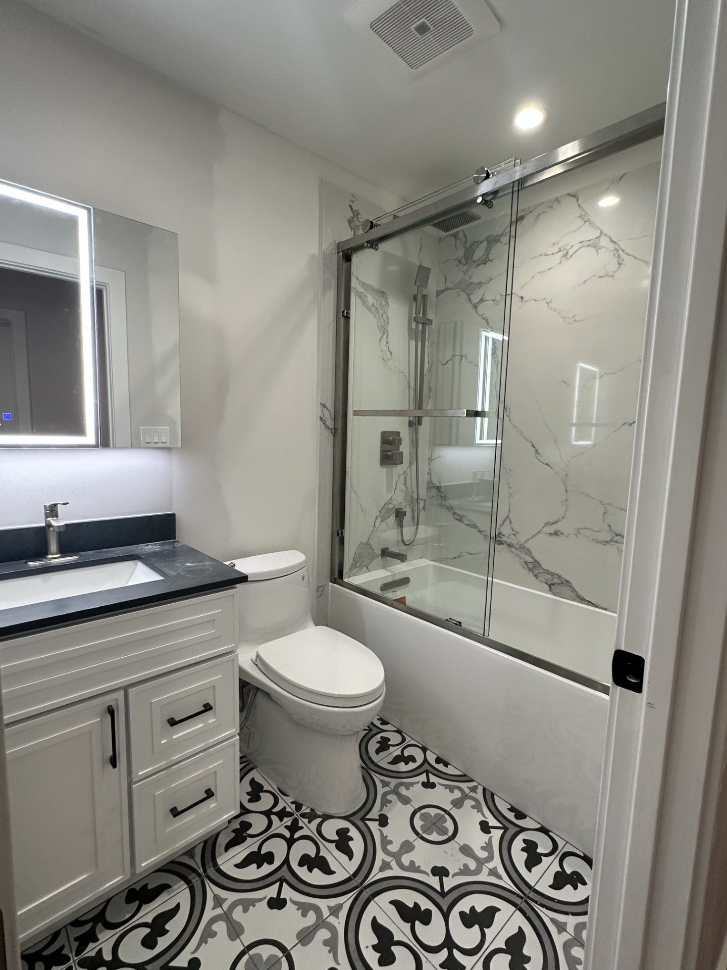 A kitchen with white cabinets and stainless steel appliances