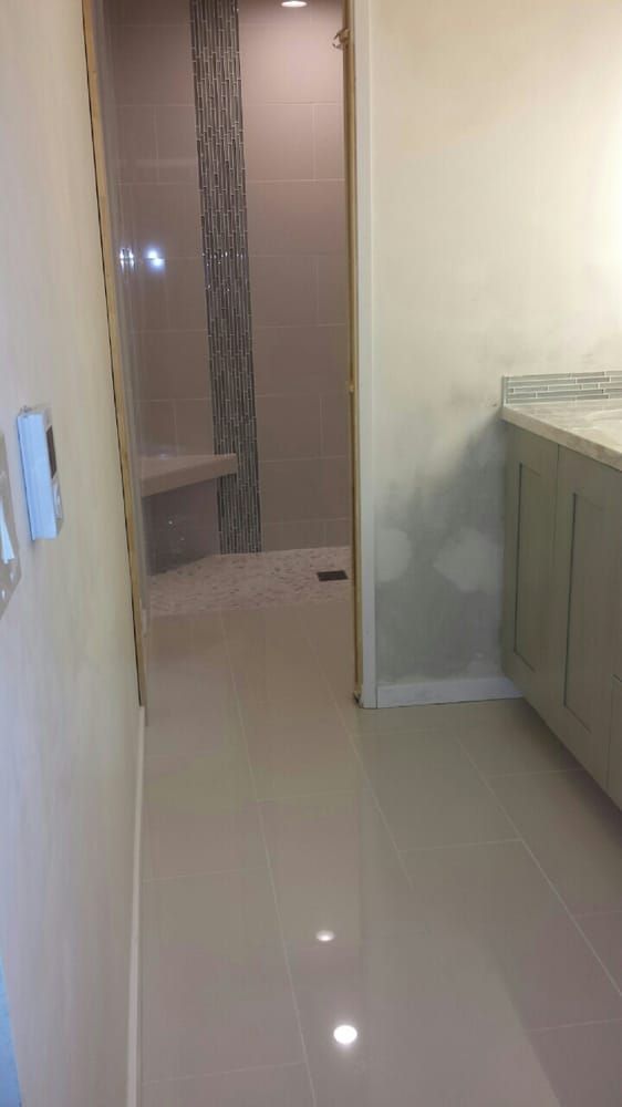 A bathroom with a walk in shower and a sink.