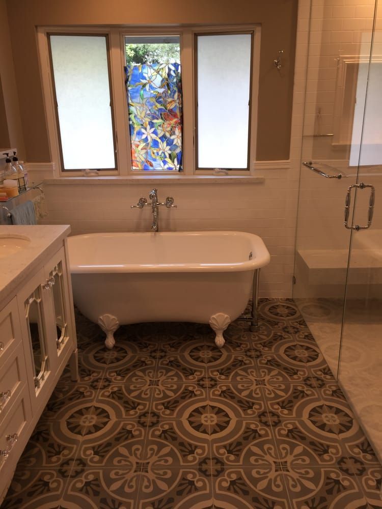 A bathroom with a claw foot tub and a stained glass window.