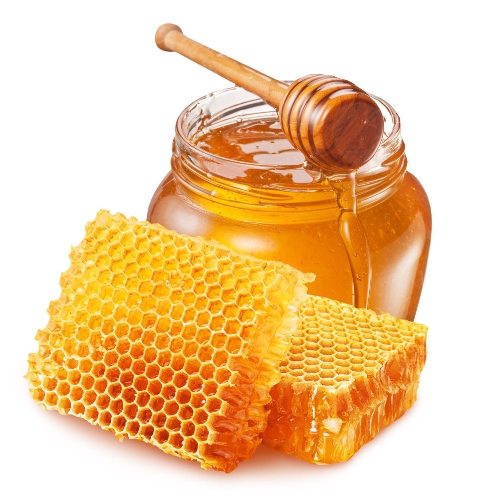 Jar of honey with a wooden honey dipper, and two pieces of honeycomb.