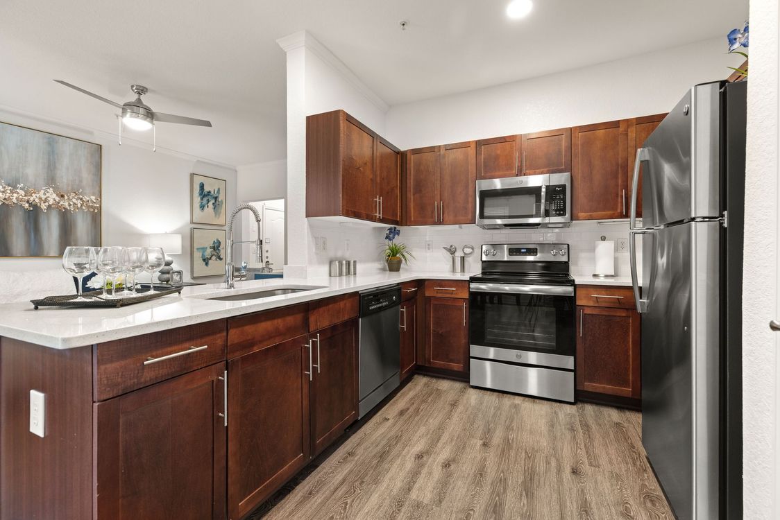 Living room with blue sofa, artwork, and open view to dining area.