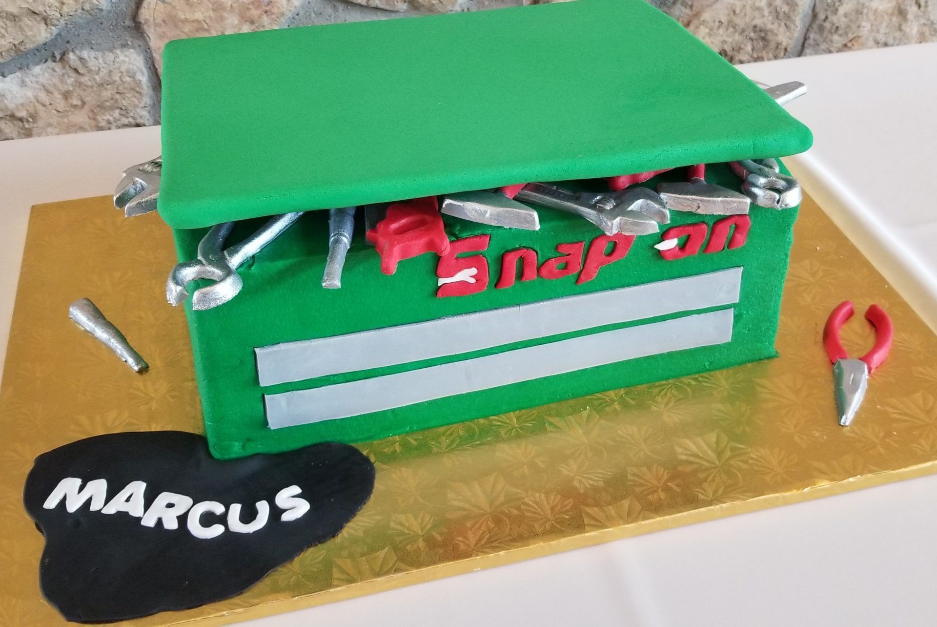 A snap on toolbox cake with the name marcus on it