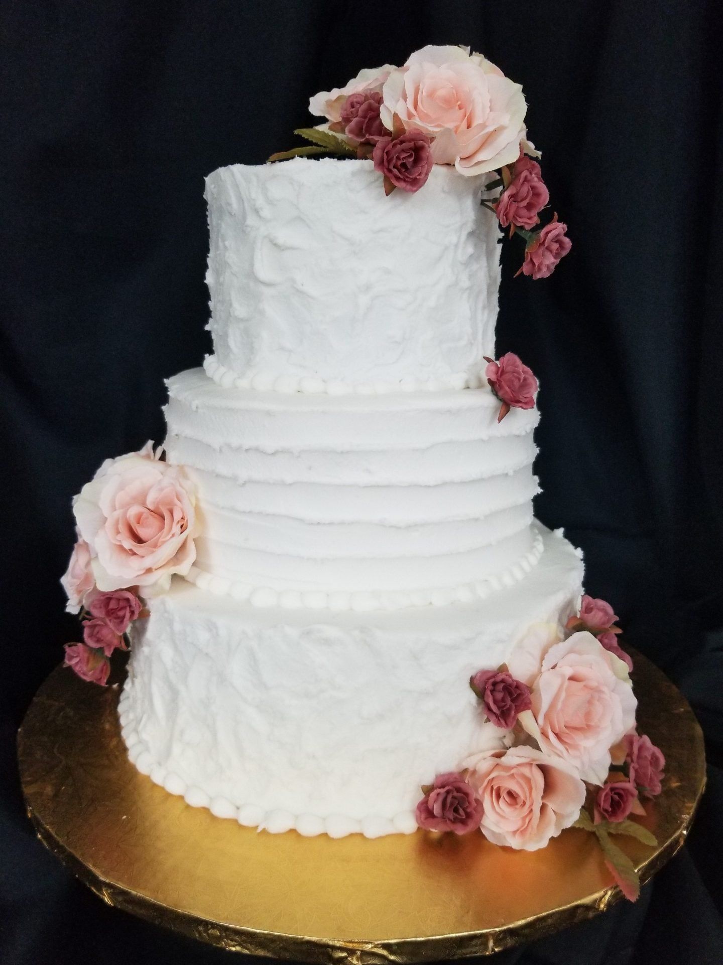 A large white wedding cake is sitting on top of a table.