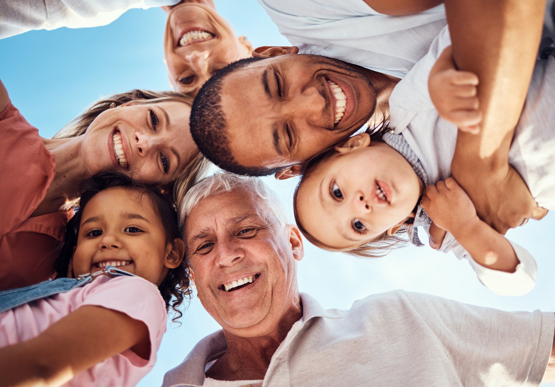Smiling diverse family huddle, joyful bonding on vacation together.