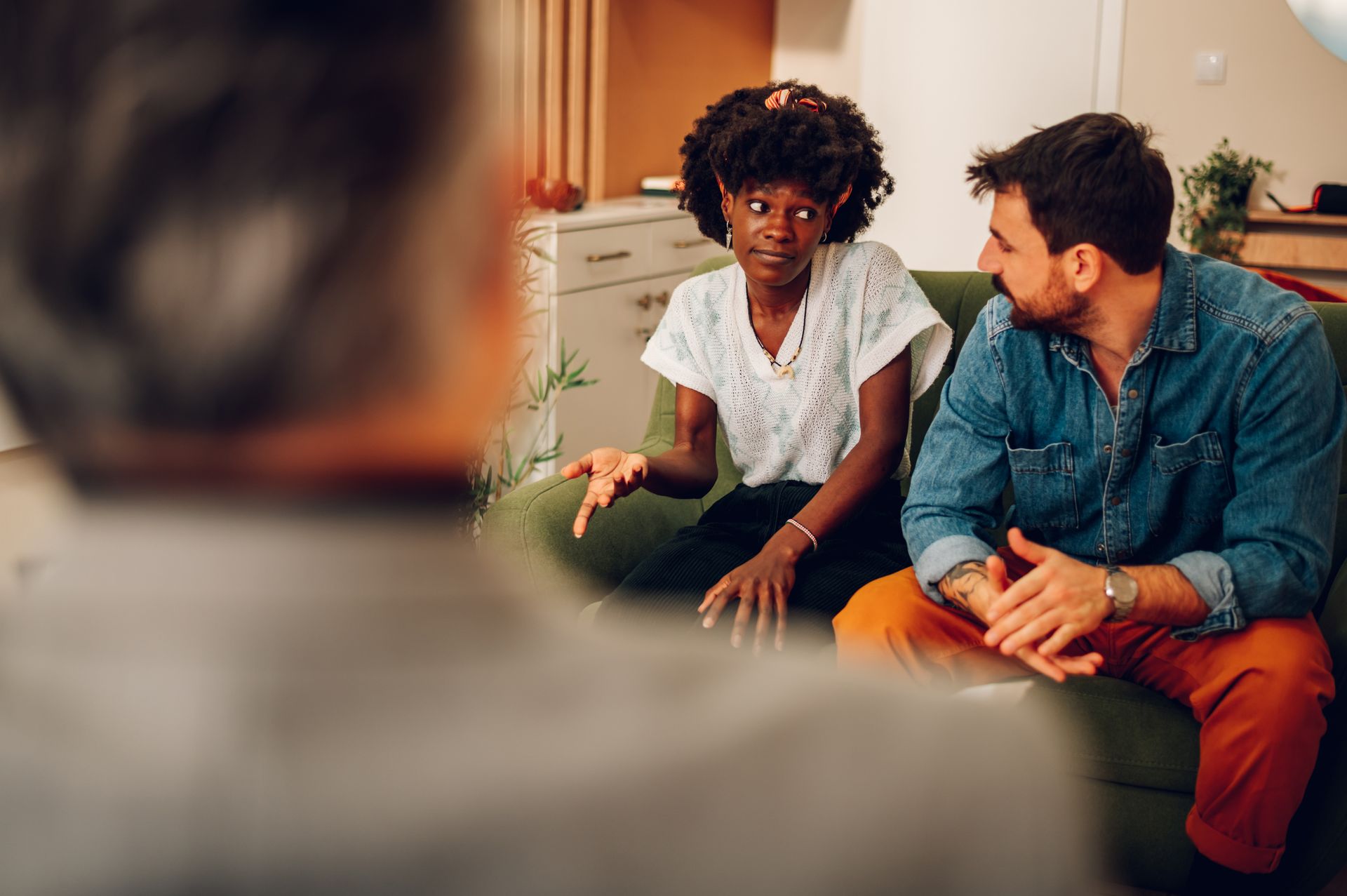 A diverse couple talk to a counselor to resolve their issues before choosing divorce.