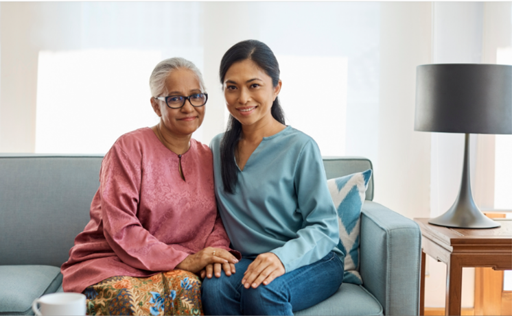 A portrait of a mother and her daughter seated in a living room, after working with a lawyer.