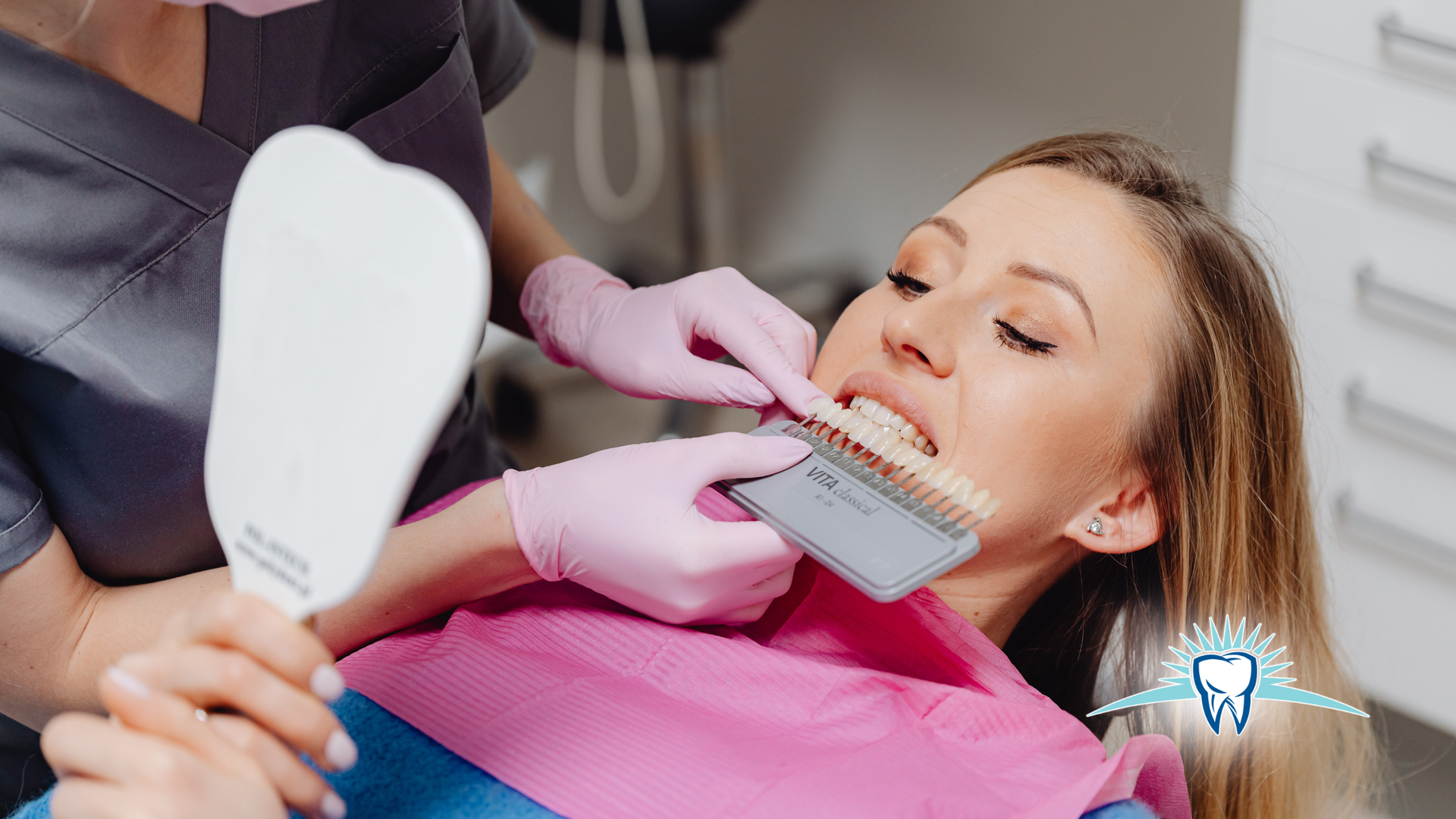 Dentist holding shade guide up to patient's teeth in a dental office.