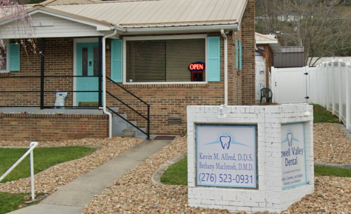A man and a woman are standing back to back and smiling.