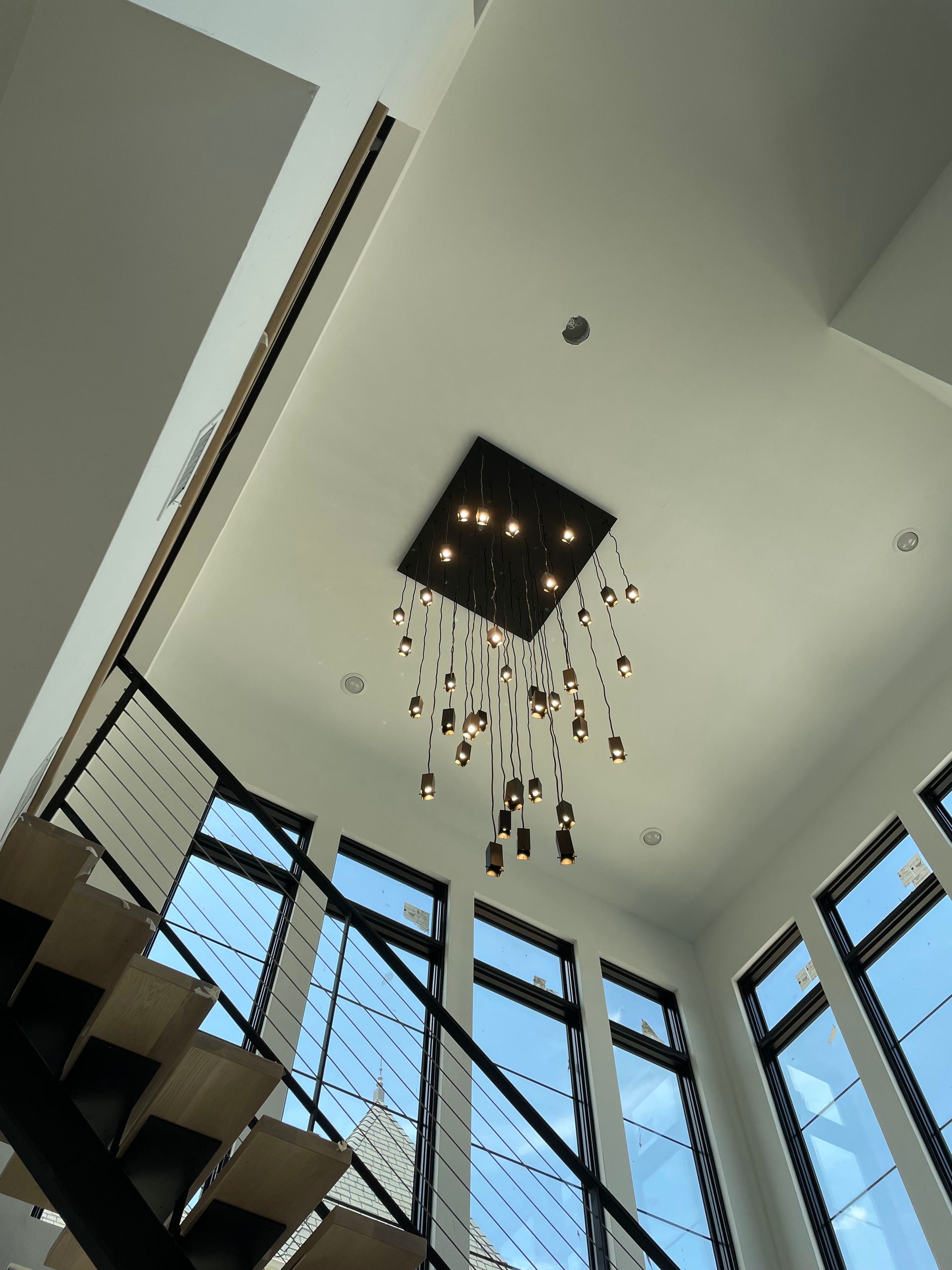 Looking up at a staircase with a chandelier hanging from the ceiling