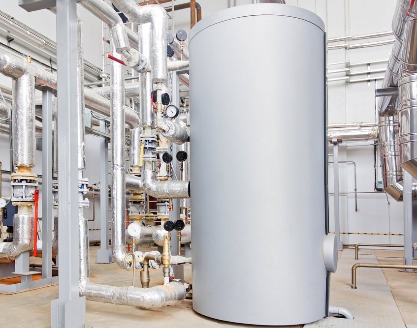 A Large Gray Tank is Sitting in a Factory Surrounded by Pipes — Plumbtek Solutions In Mudgeeraba, QLD