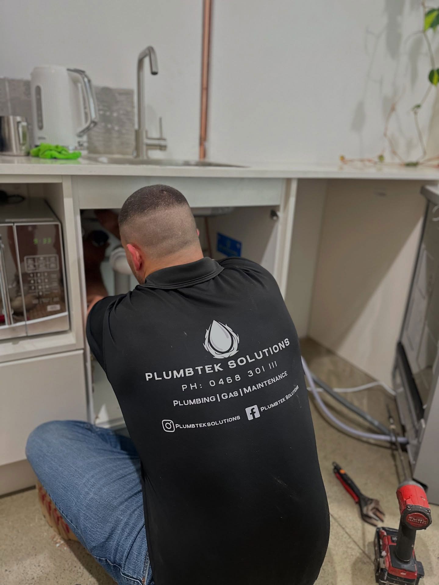 Plumber Fixing Pipes Under The Sink