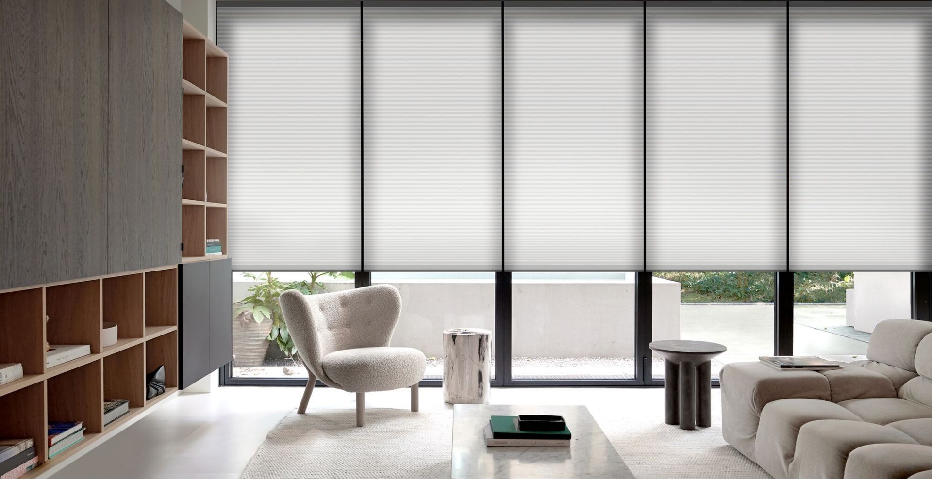 A cozy living room with a couch, coffee table, and cellular window shade