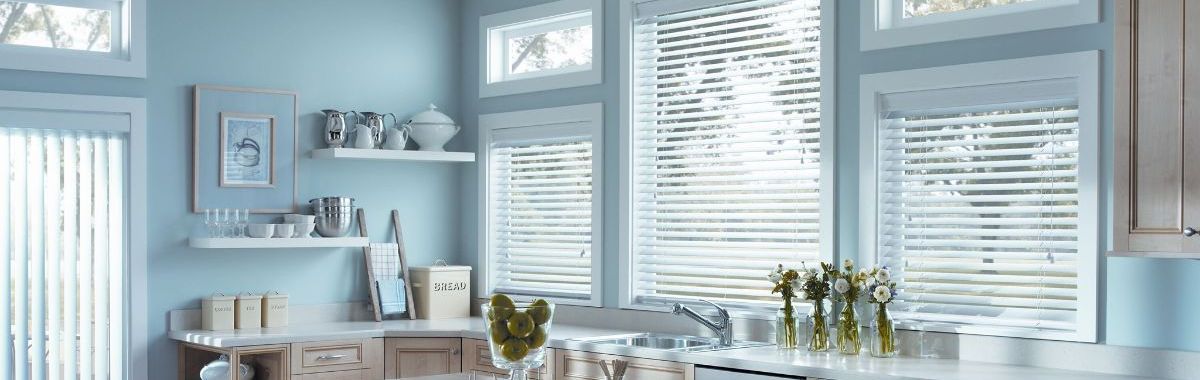 A kitchen with blue walls and white blinds on the windows.