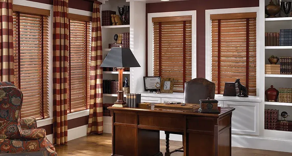 Cozy home office featuring real wood blinds and a desk.