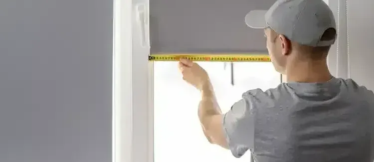 a window blinds installer  measuring a window