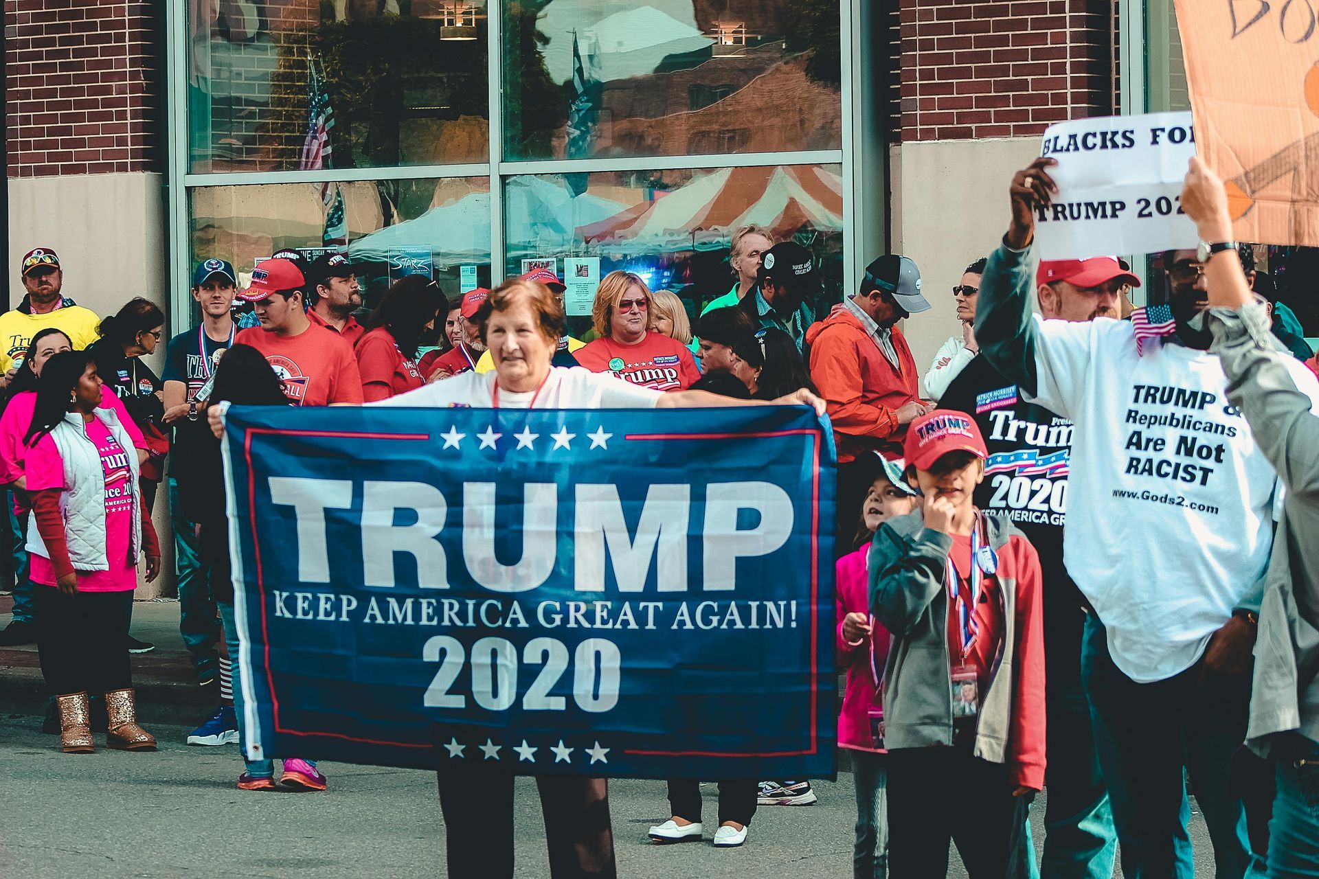 Woman holding a Trump 2020 flag, smiling