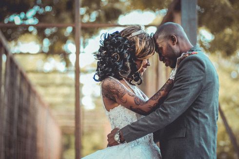 A bride and groom are hugging each other on their wedding day.