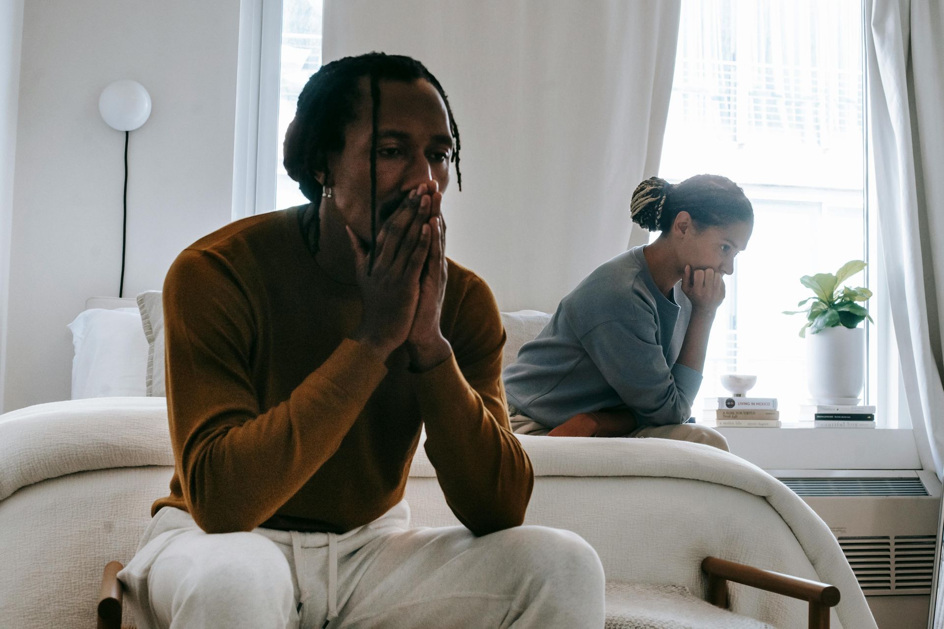 A man and a woman are sitting on a couch in a living room.