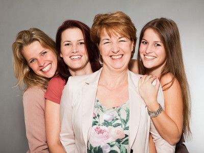 A group of women are posing for a picture together and smiling.