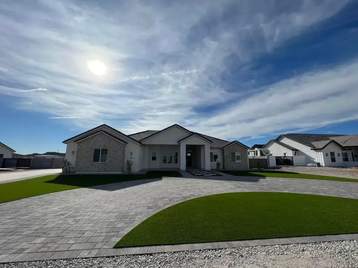 Completed front yard renovation with defined garden beds stone walkway and low maintenance desert shrubs in Arizona