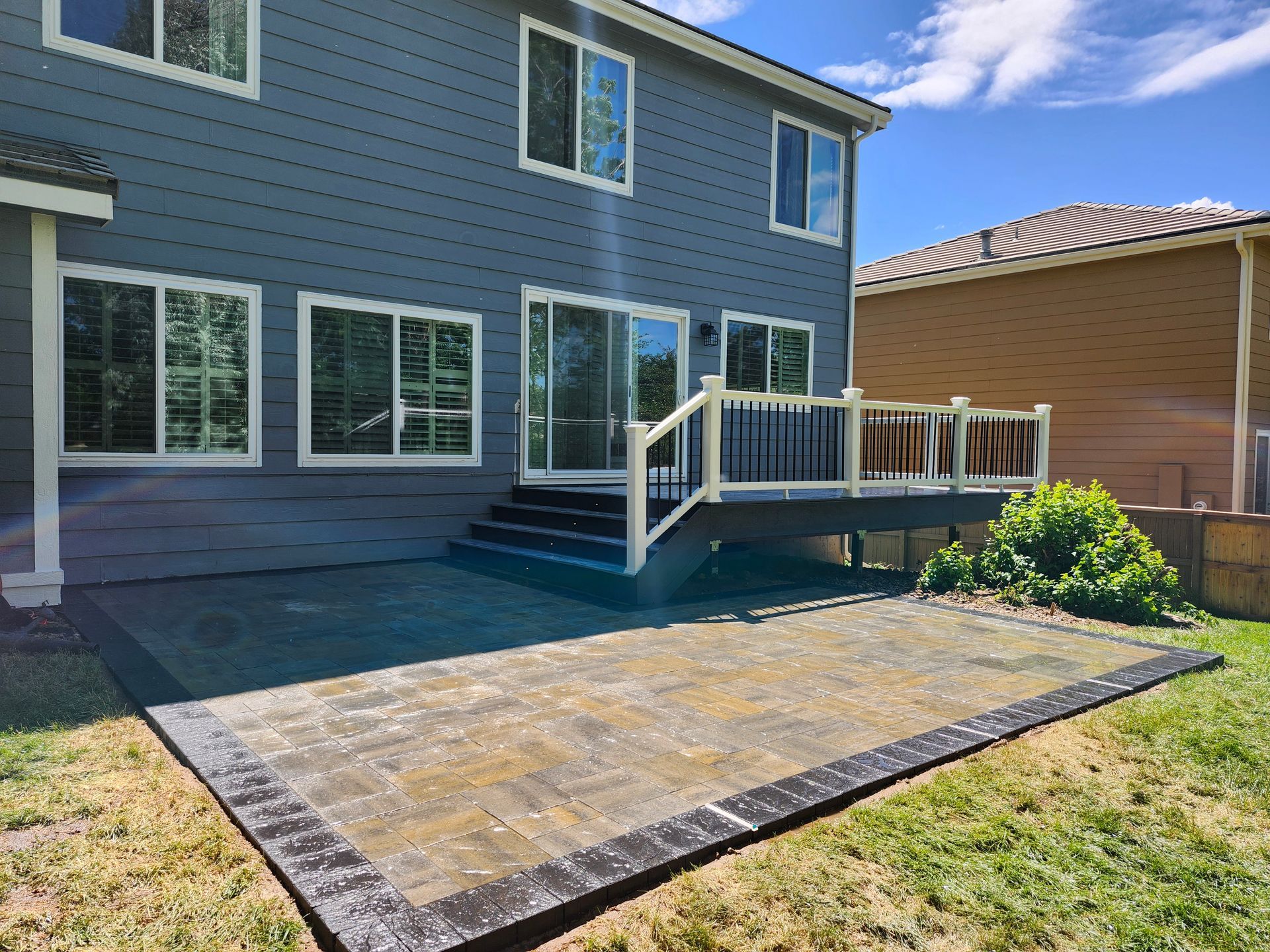 The backyard of a house with a patio and a deck.