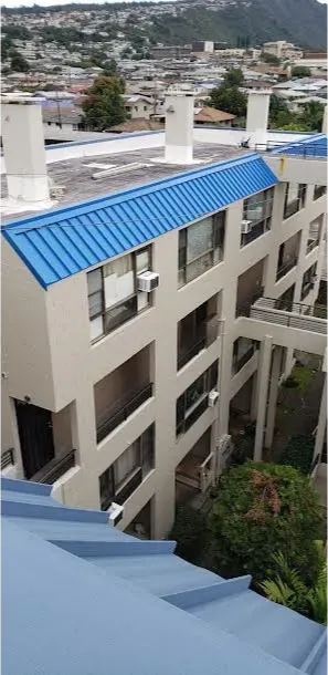 A large building with a blue roof and balconies.