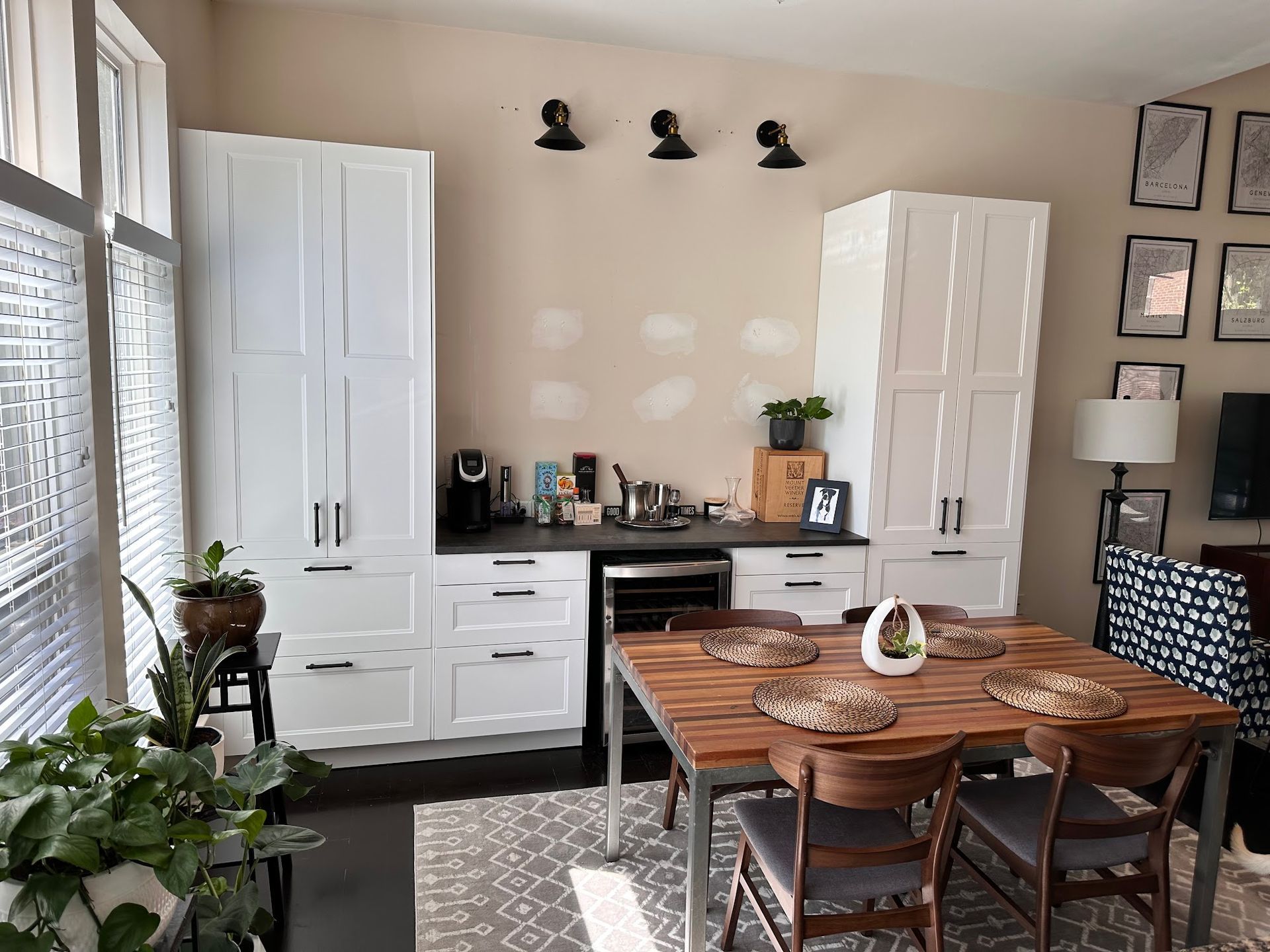 A dining room with a wooden table and chairs and white cabinets.