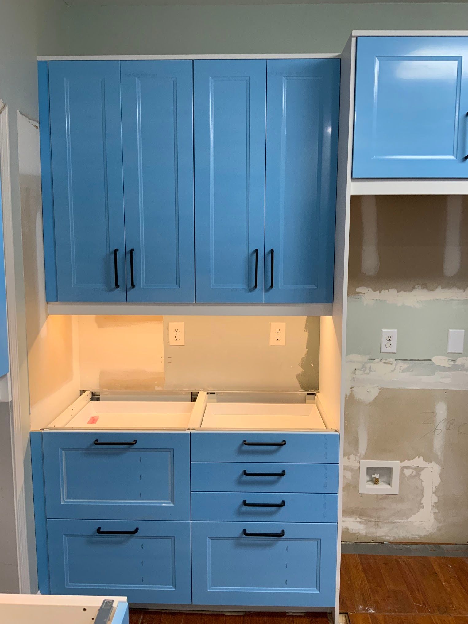 A kitchen with blue cabinets and drawers is being remodeled.