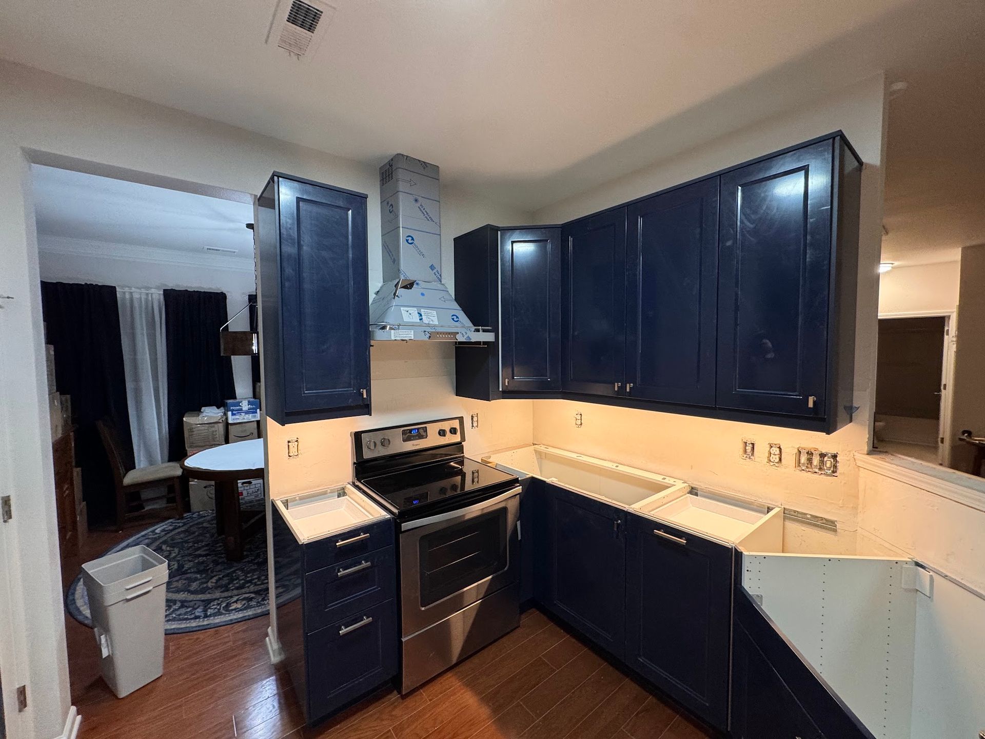 A kitchen with blue cabinets and stainless steel appliances.
