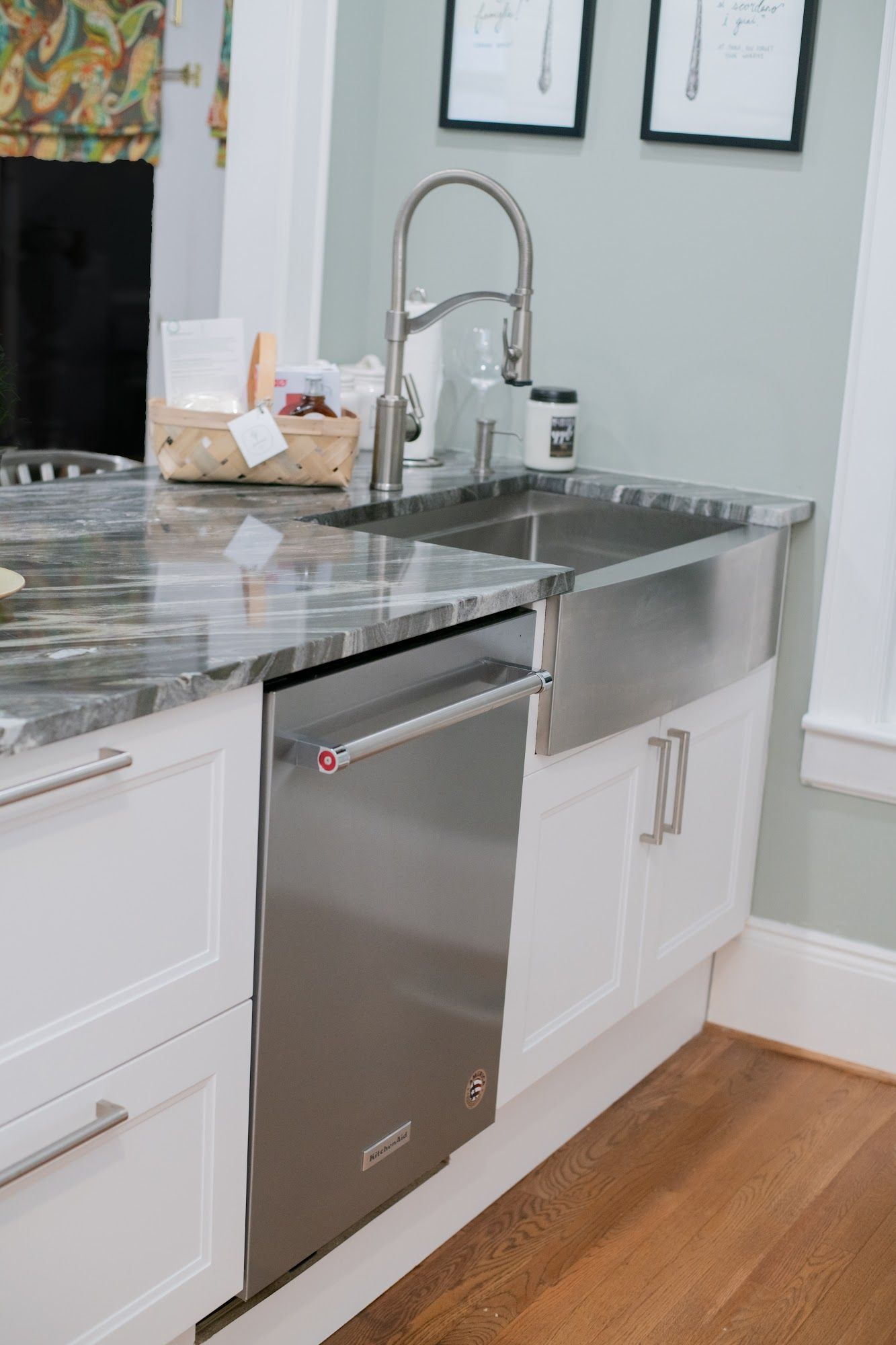 A kitchen with a stainless steel sink and a dishwasher.