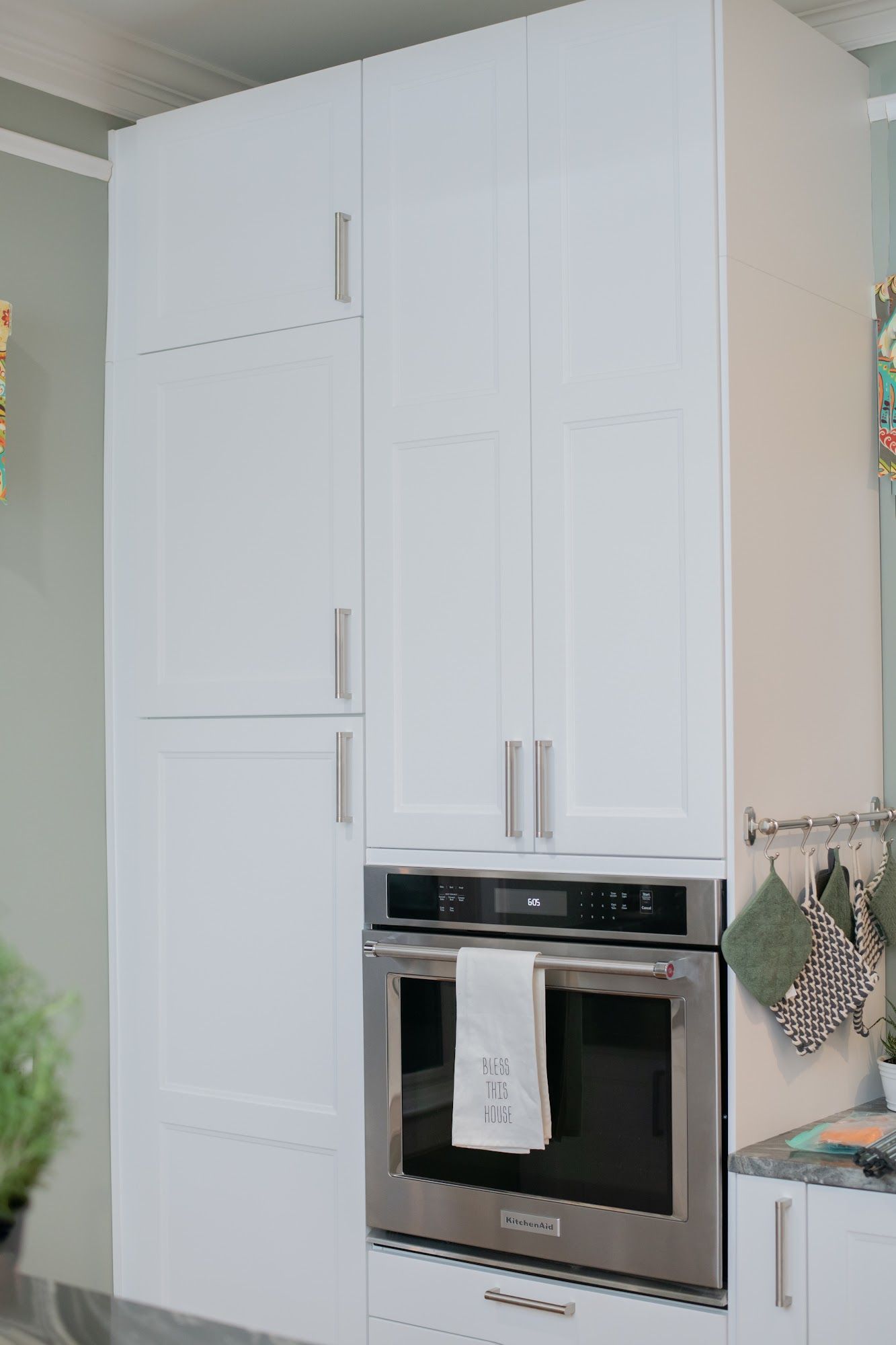 A kitchen with white cabinets and a stainless steel oven.