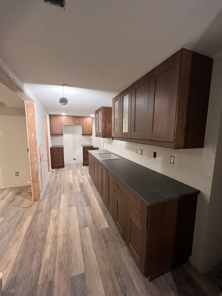 A kitchen with wooden cabinets and a black counter top.