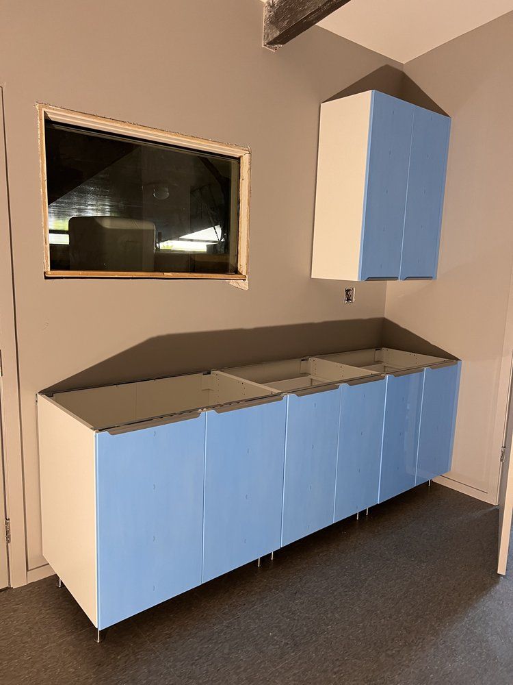 A kitchen with blue cabinets and a window