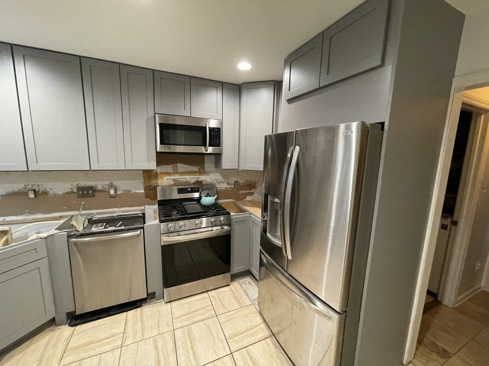 A kitchen with stainless steel appliances and gray cabinets
