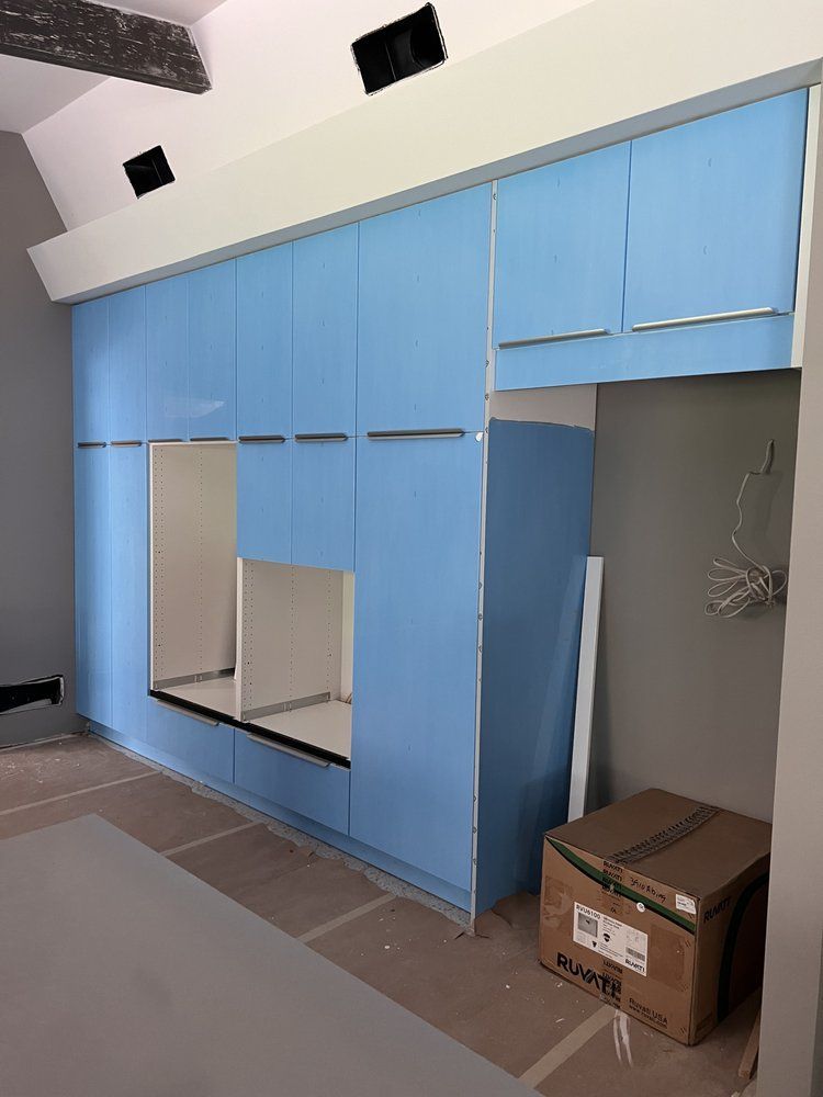 A room with blue cabinets and a cardboard box on the floor.