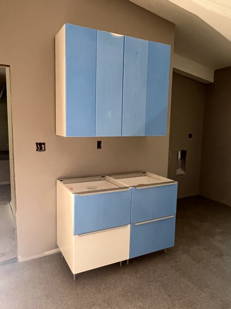 A kitchen with blue and white cabinets and drawers